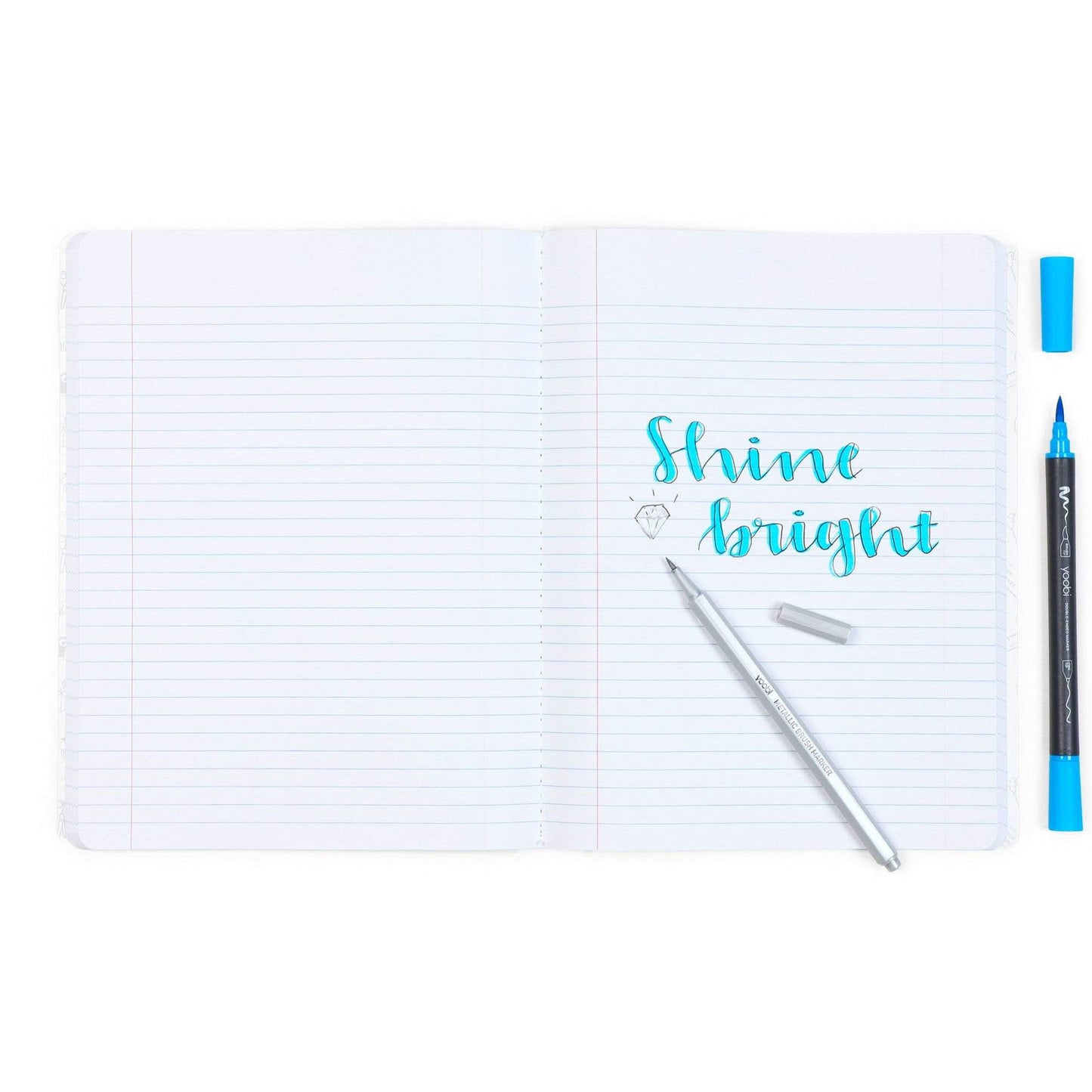 inside of open composition book showing "Shine bright" written in markers