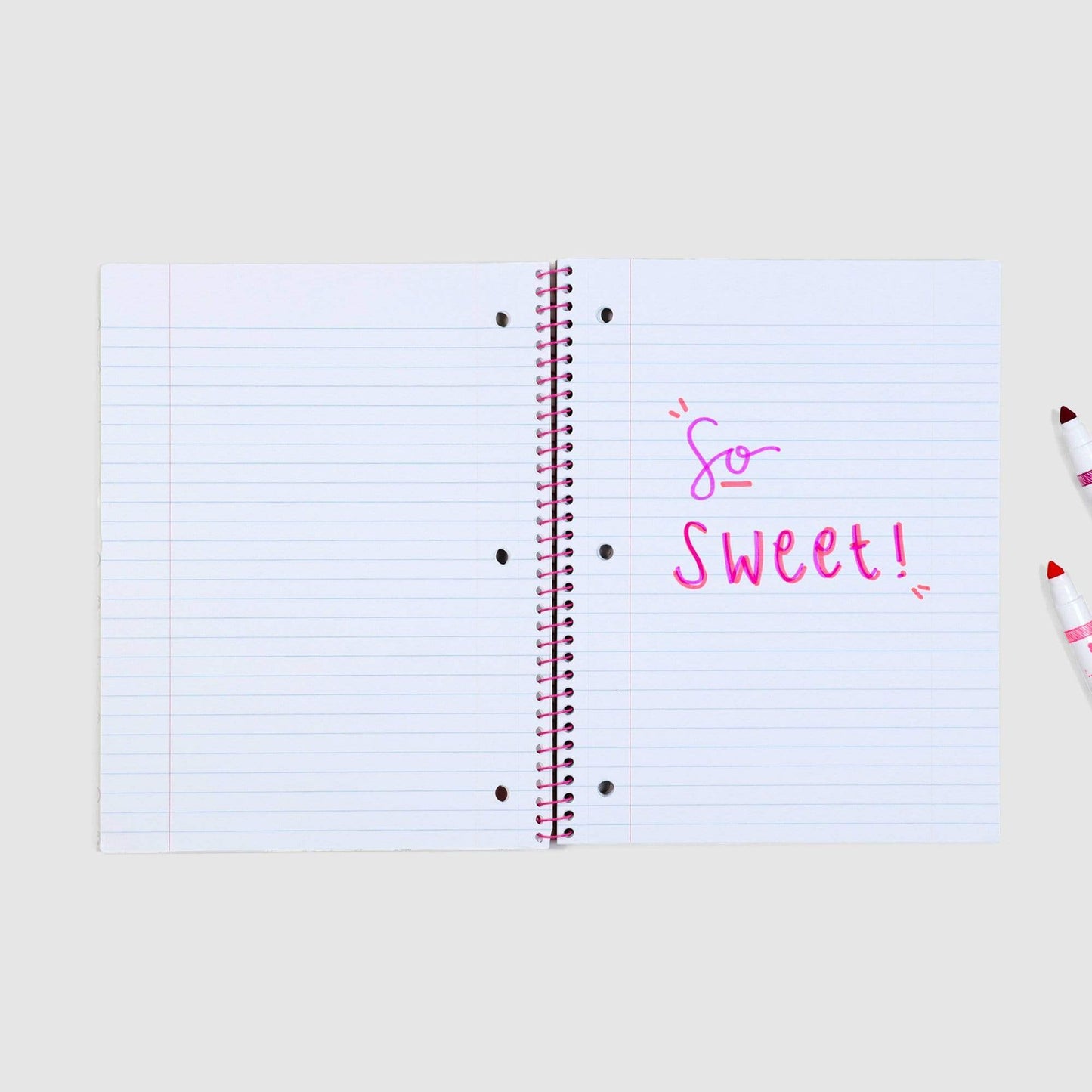 inside of open one subject spiral notebook showing 3-hole punch and wide-ruled paper