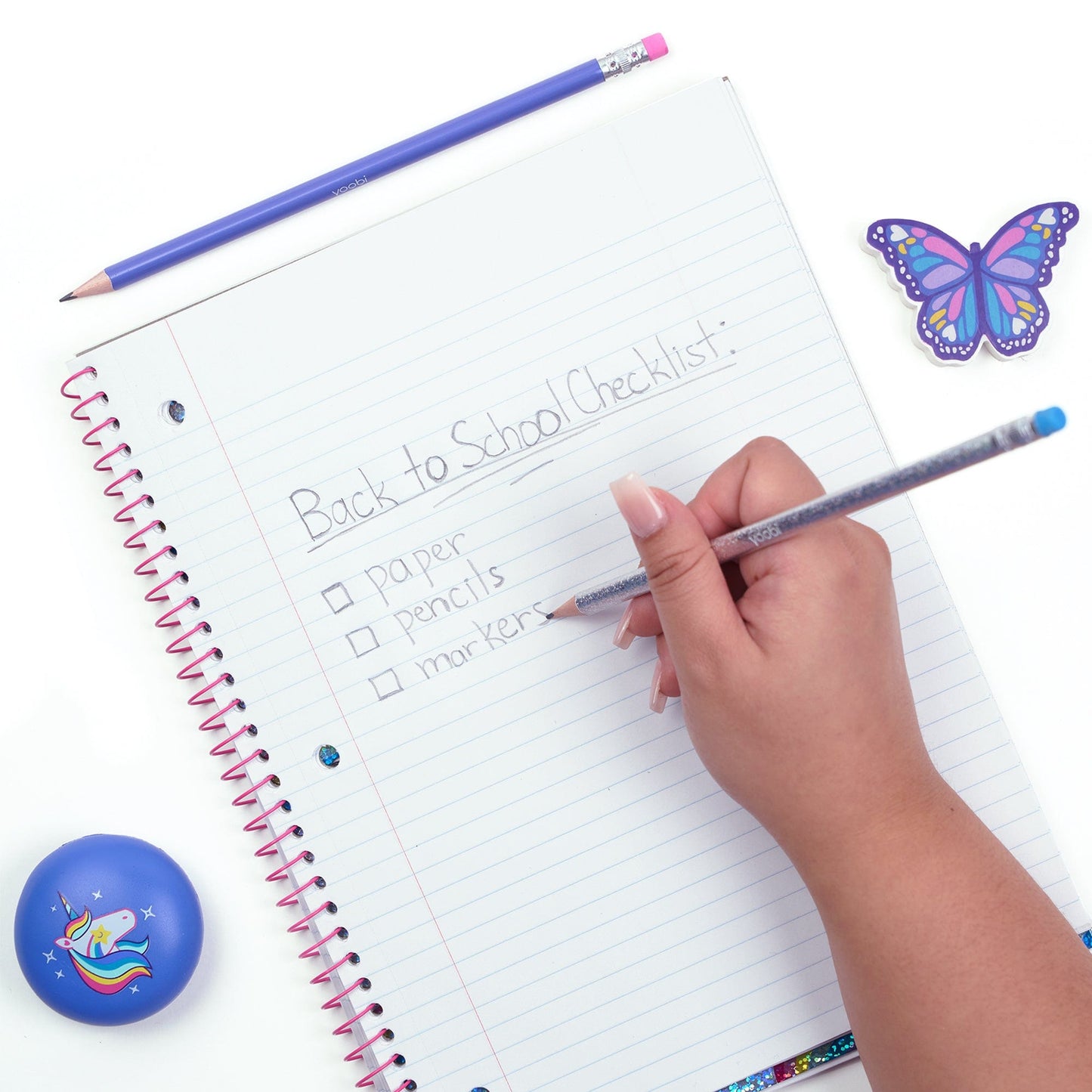 Silver glitter pencil shown held in hand writing on paper